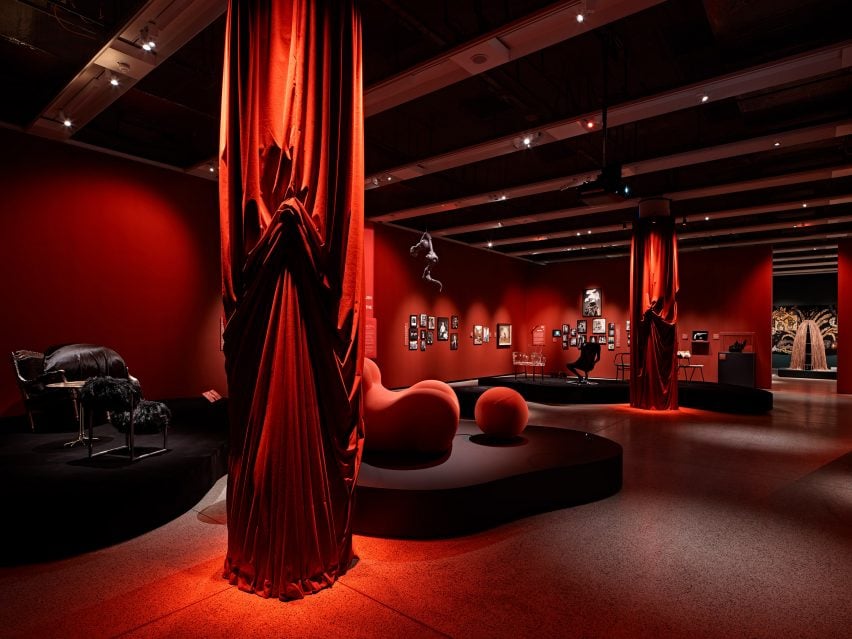 Chairs, sofas, red curtains and other objects displayed in the exhibition