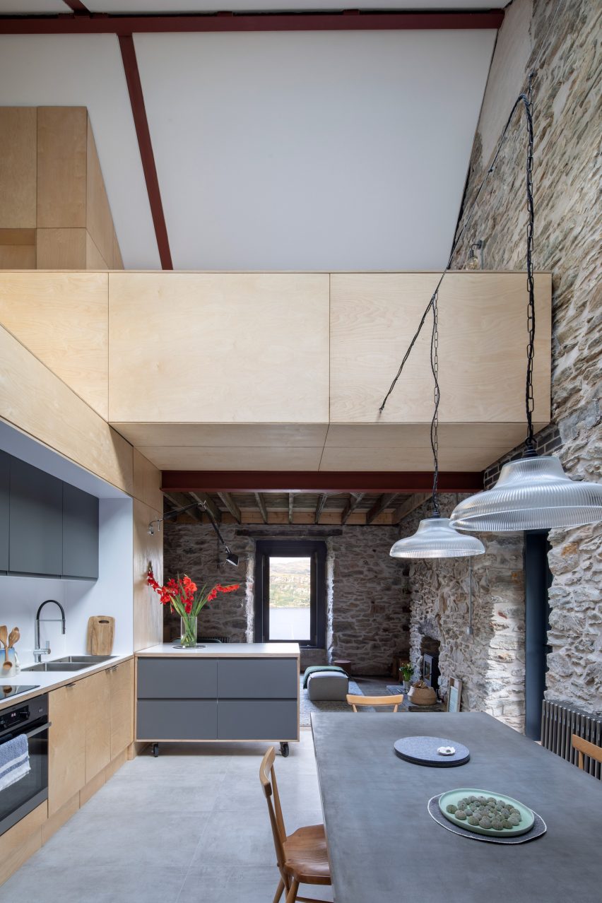 Open-plan kitchen and dining room with exposed stone walls