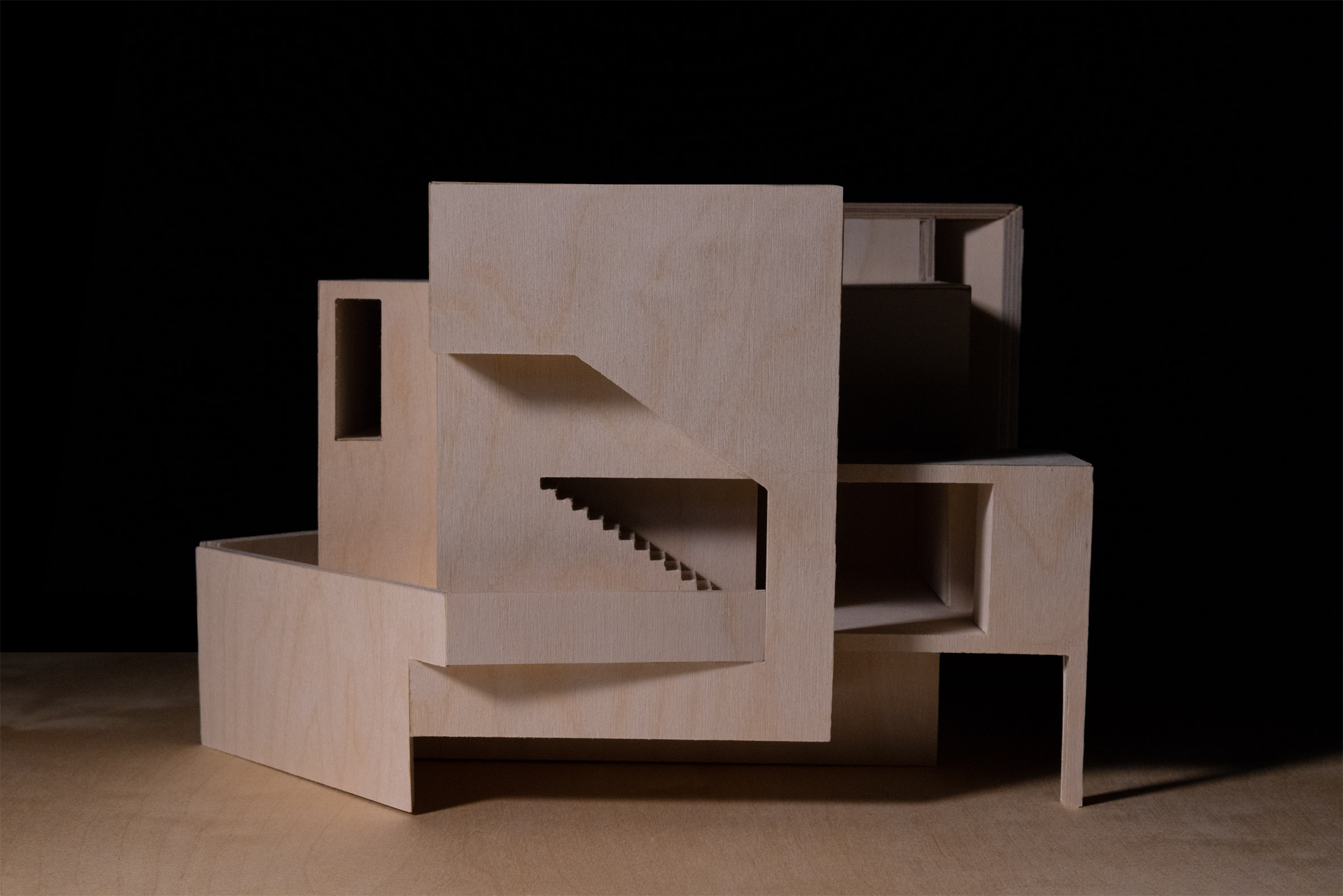 Photograph of a plywood model in front of black backdrop