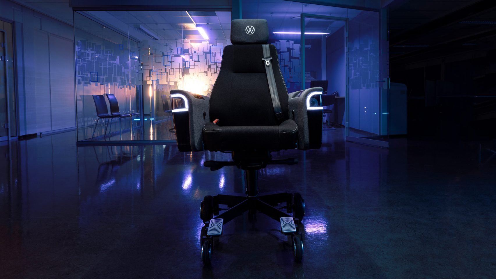 An office chair that is capable of driving at 20kmh is shown front-on, in a darkened office space with some low blue lighting behind.