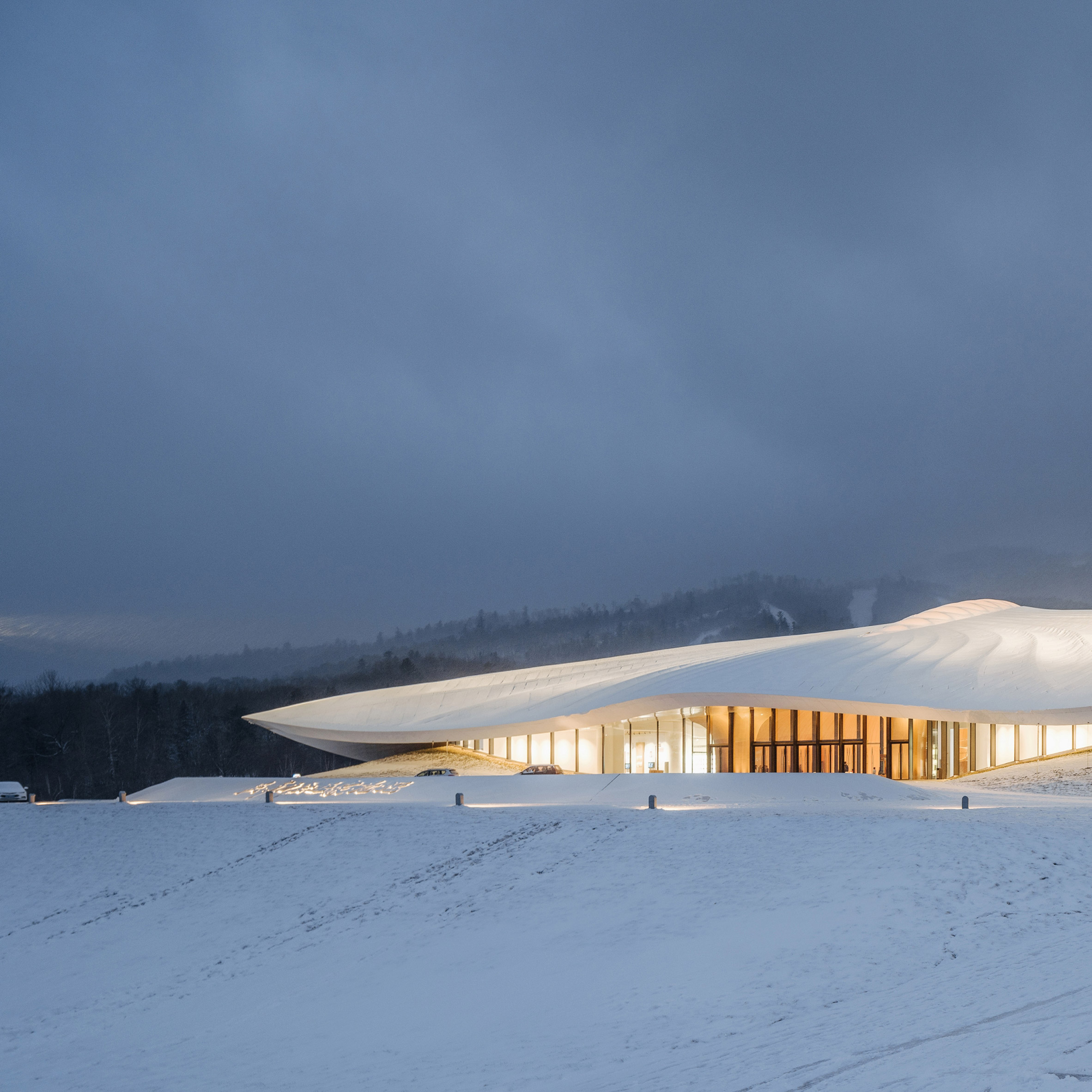 White conference centre with overhanging roof on white snow