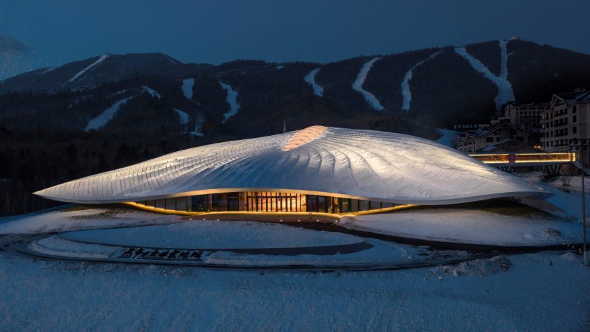 Sinuous conference centre lit up by hidden lights