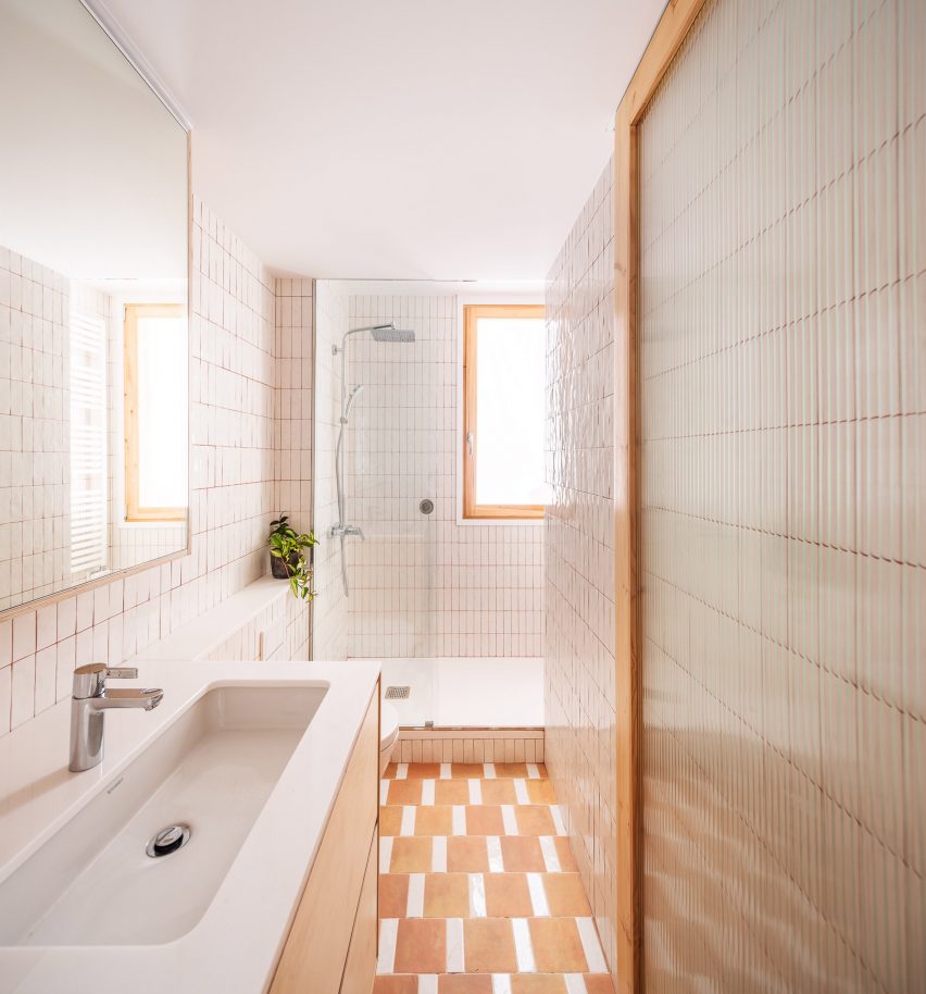 Cuarto de baño con azulejos de terracota y blanco brillante 