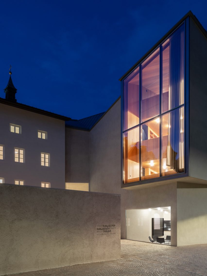 Exterior image of Brixen Public Library lit at night