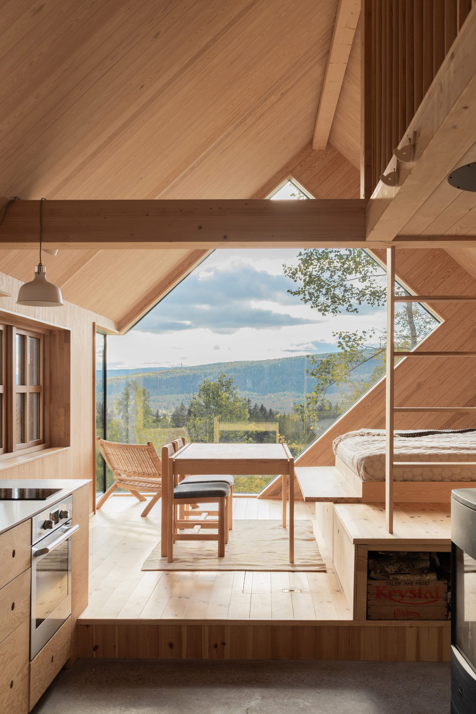 Wood-lined living room overlooking Norwegian landscape