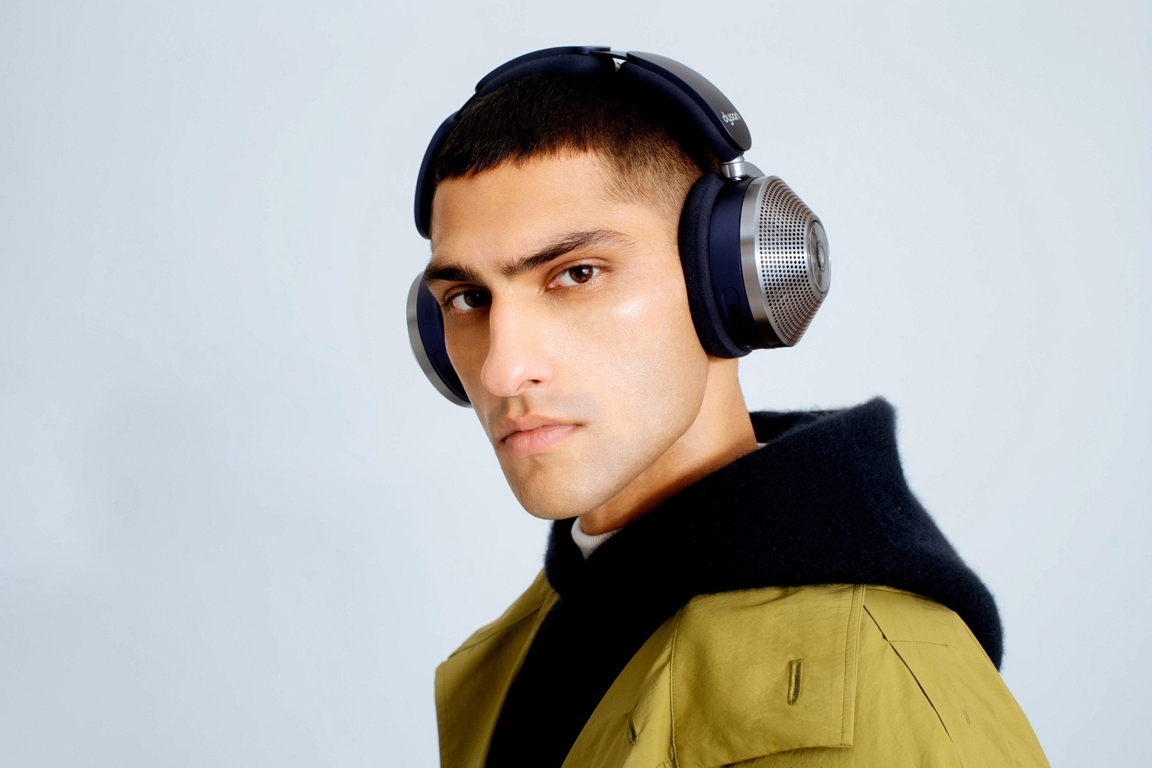 A man wearing silver Dyson headphones