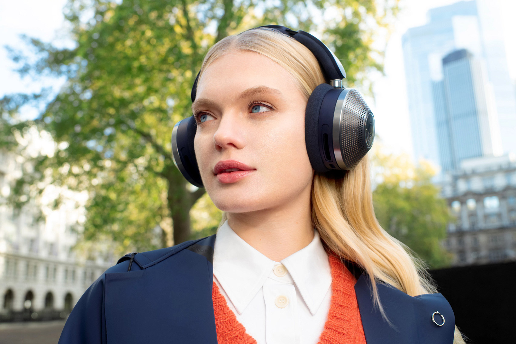 A woman wearing Dyson Zone headphones outside
