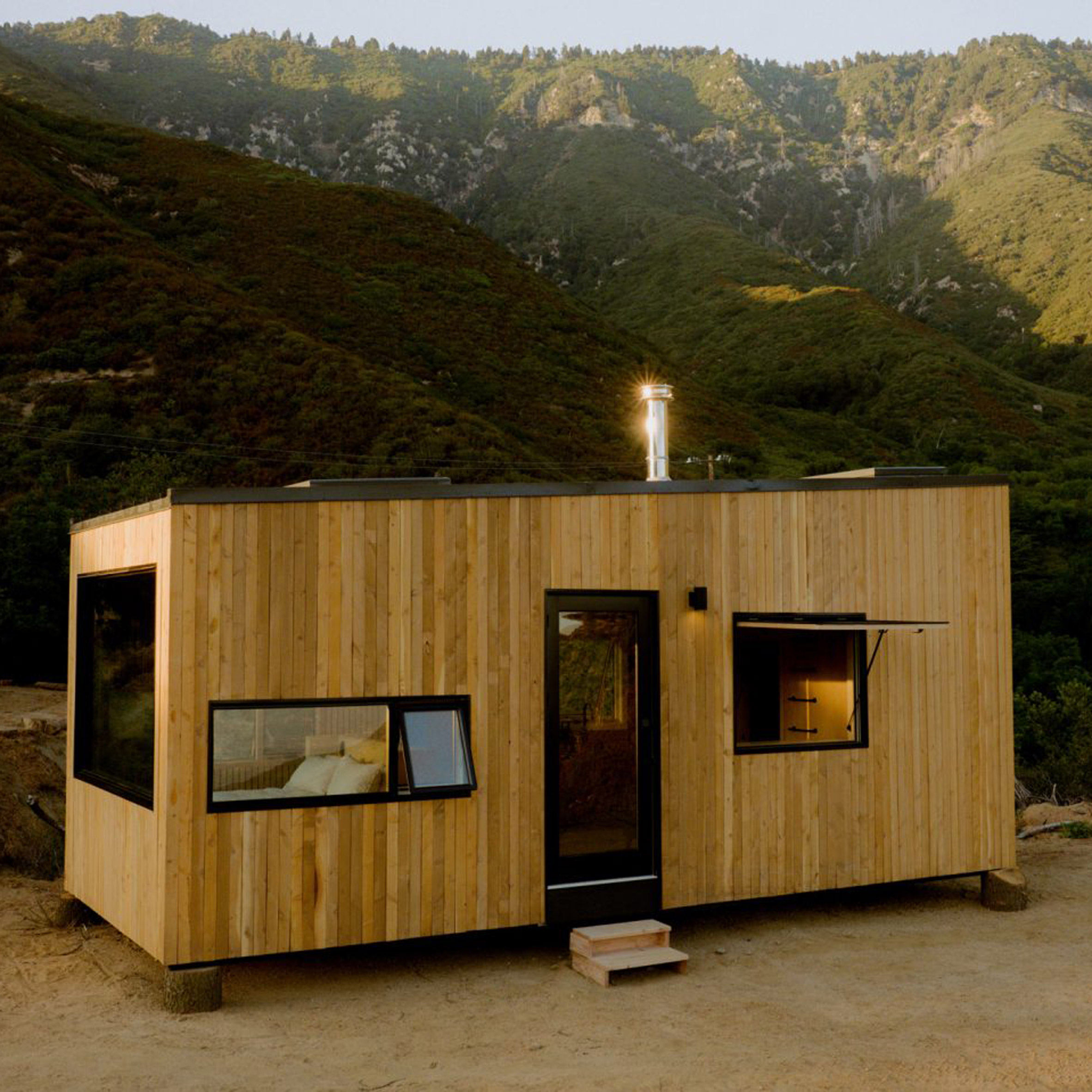 Image of a wooden glamping cabin with views across a mountainous setting