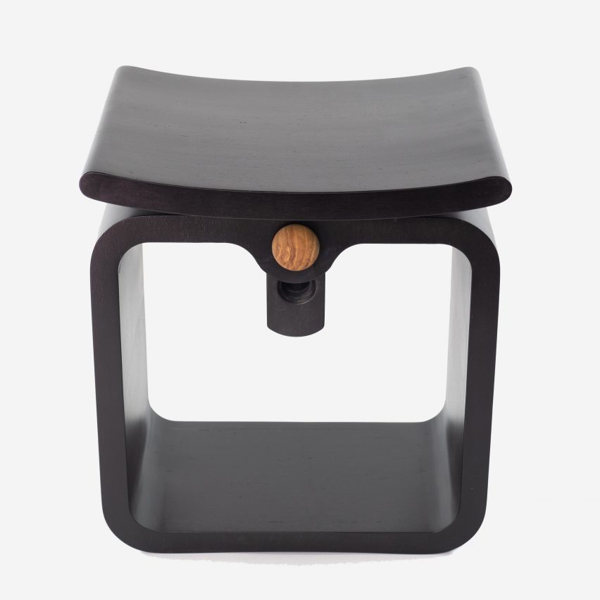 A black stool with a curved seat