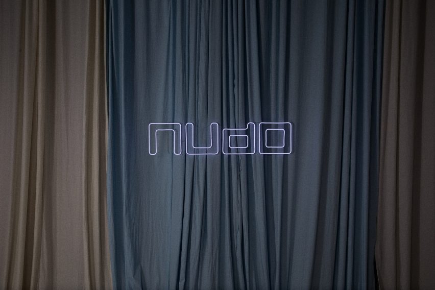 Nudo sign in front of draped fabrics