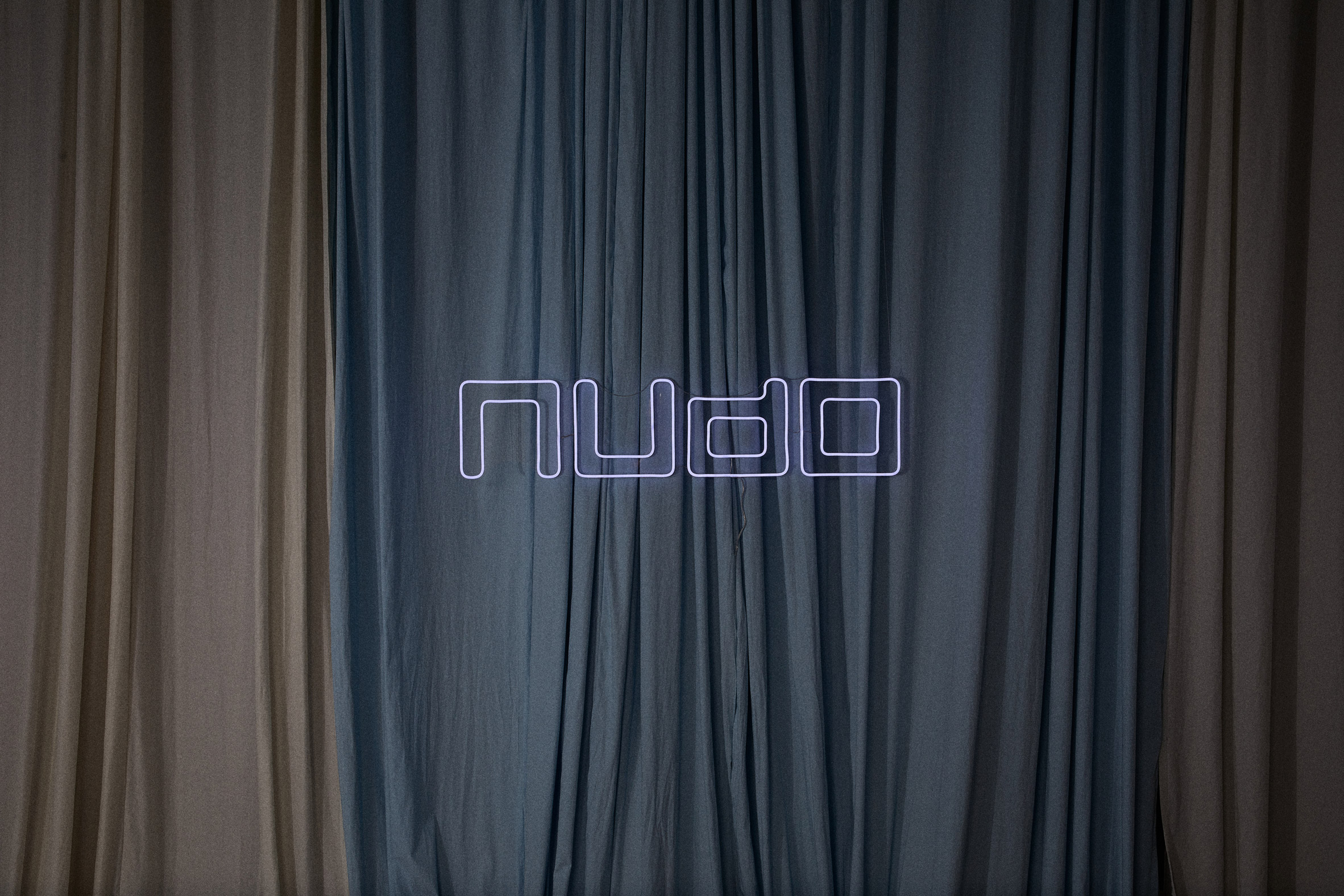 Nudo sign in front of draped fabrics