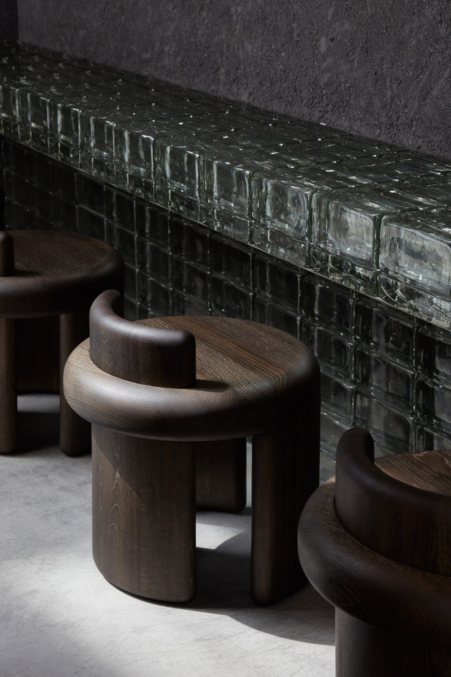 Glass-brick counter fronted by low wooden stools