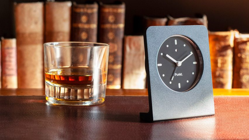 Black Punkt clock next to glass of whisky