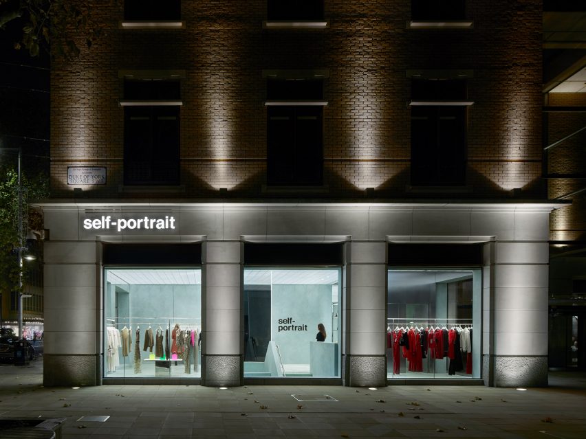 Imagen exterior de la tienda Self-Portrait iluminada de noche desde la calle 