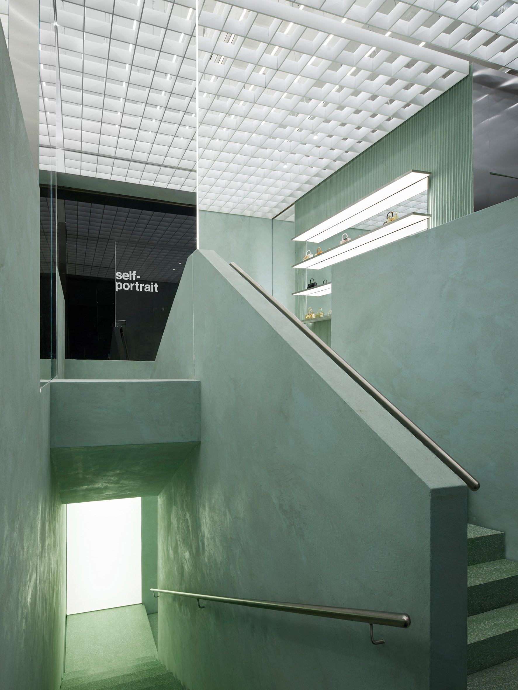 Image of a staircase that was hued mint green and surrounded by mirrors