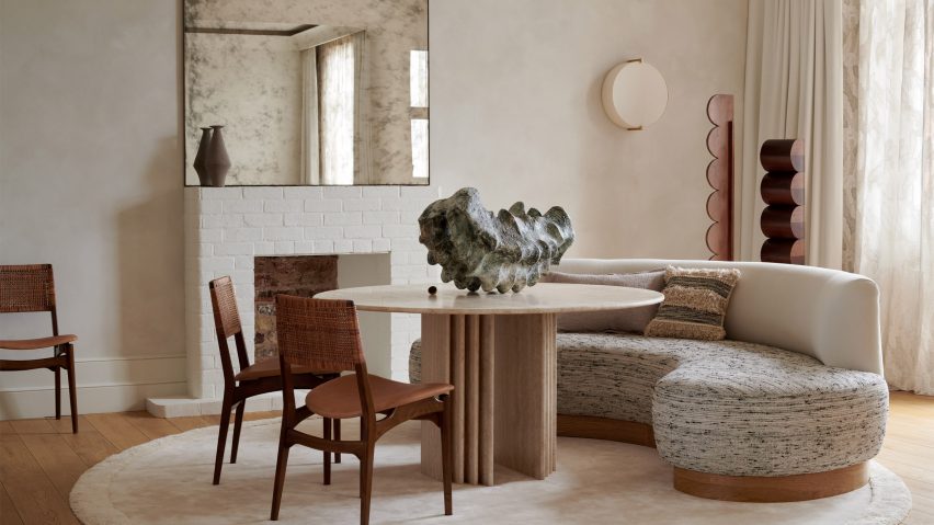 Living room with curved sofa and travertine table in The Palace Gate apartment by Tala Fustok