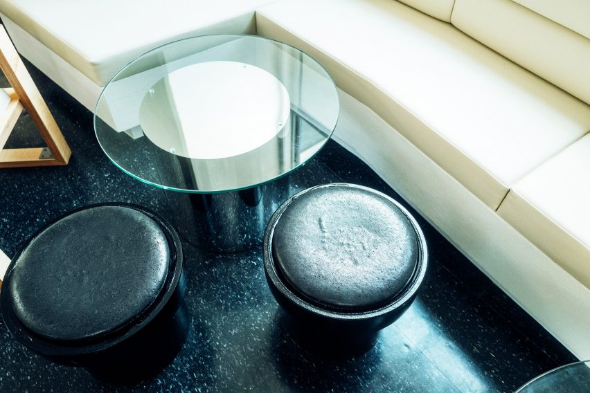 Round black stool with a glass-topped side table