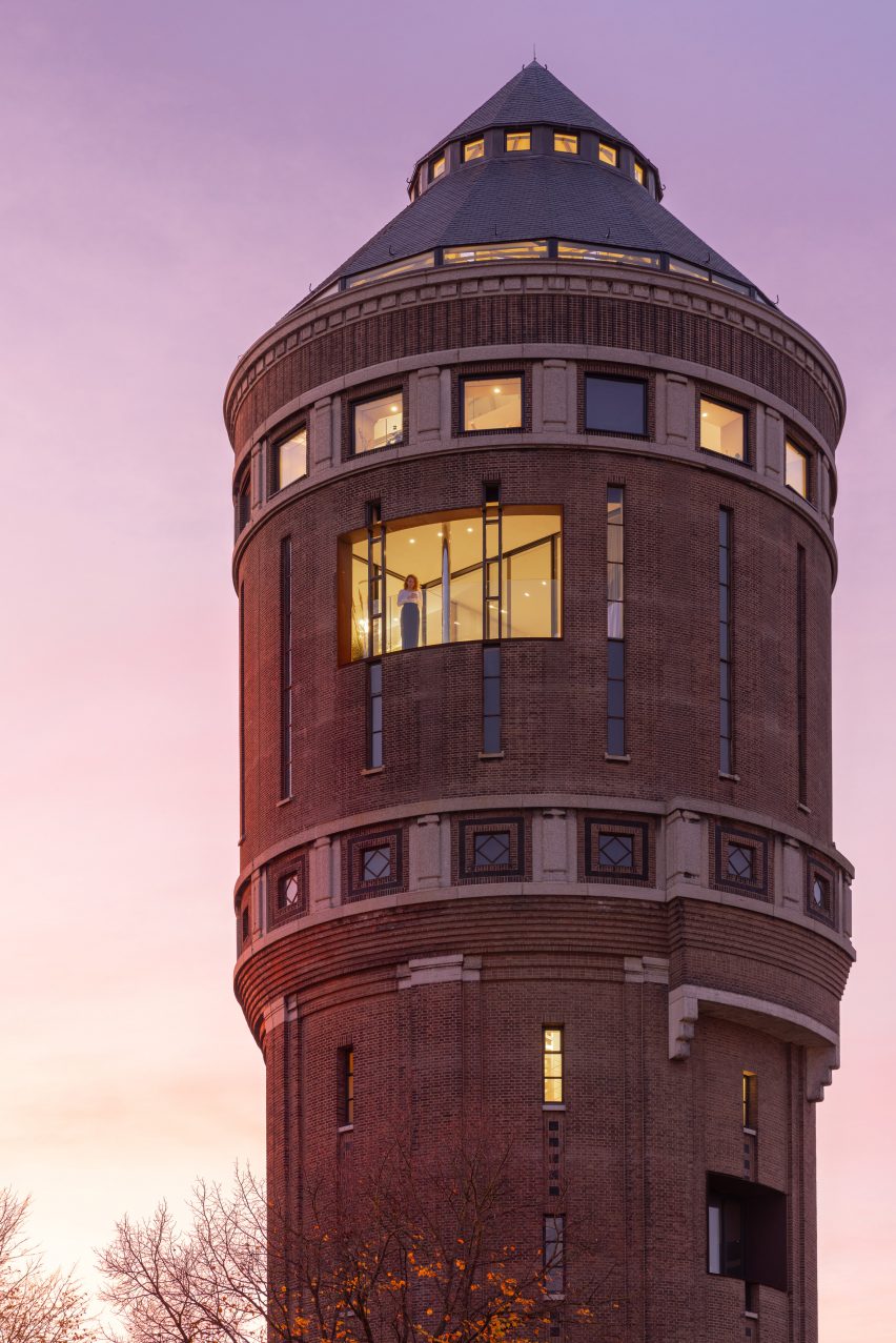 Woman looking out from apartment in old water tower