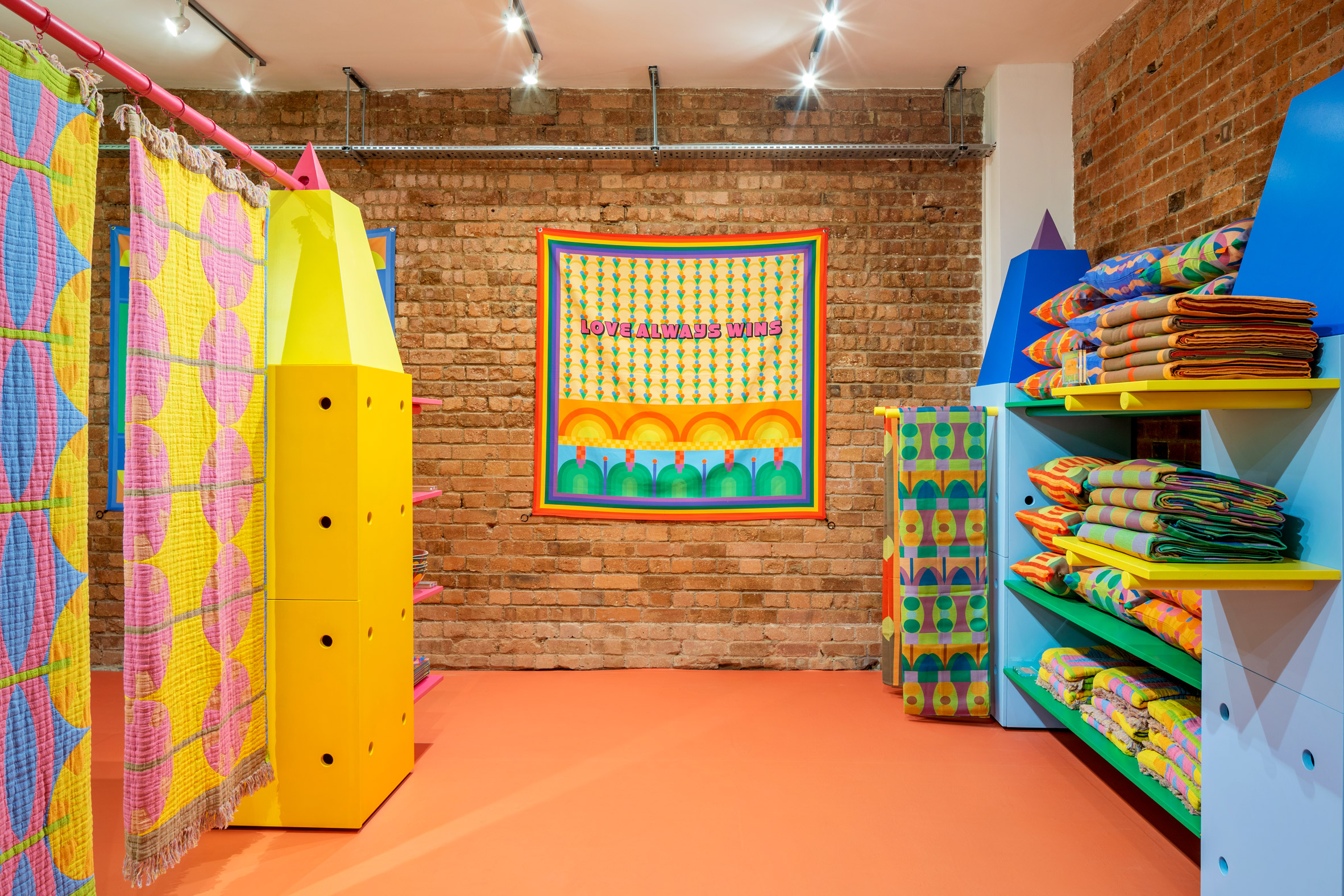 Colourful display stands holding textiles in Colourful clothes rail in Yinka Ilori's London pop-up shop