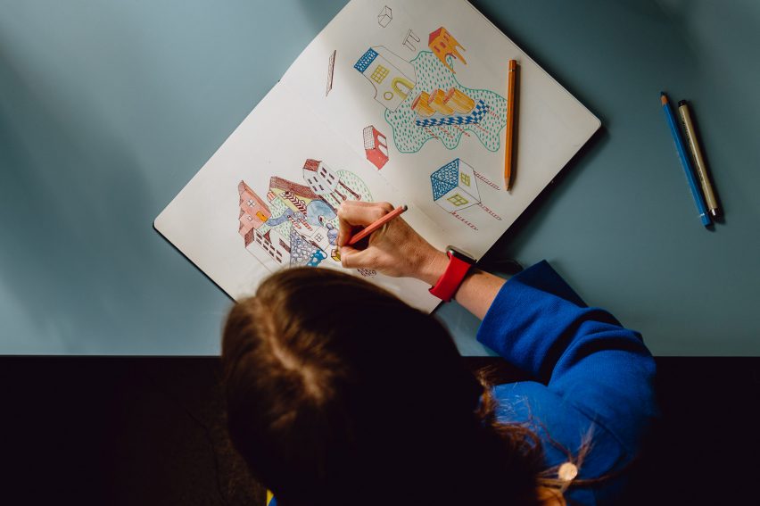 Picture of a person drawing several illustrations of houses