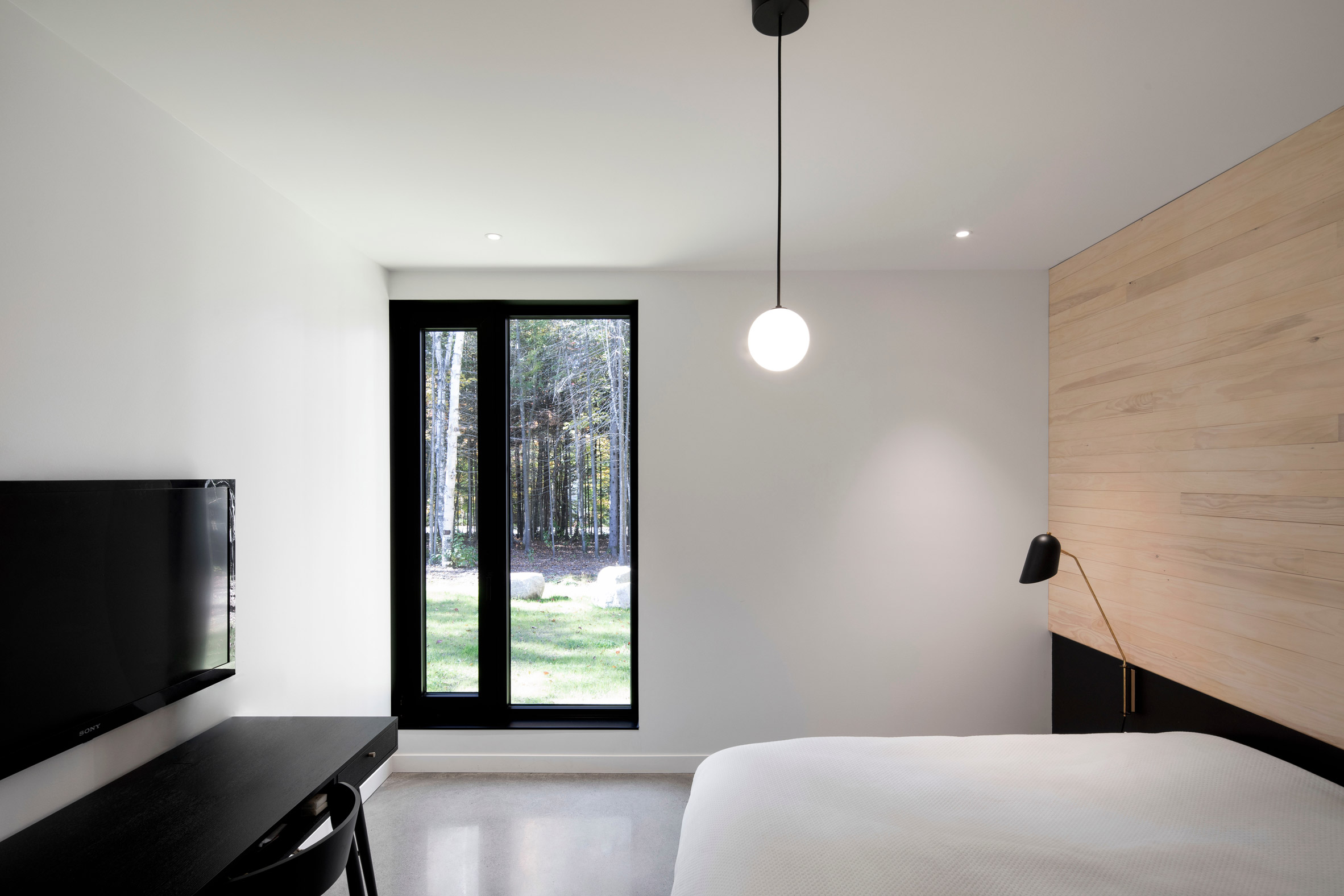 Minimalist bedroom at black house in Montreal