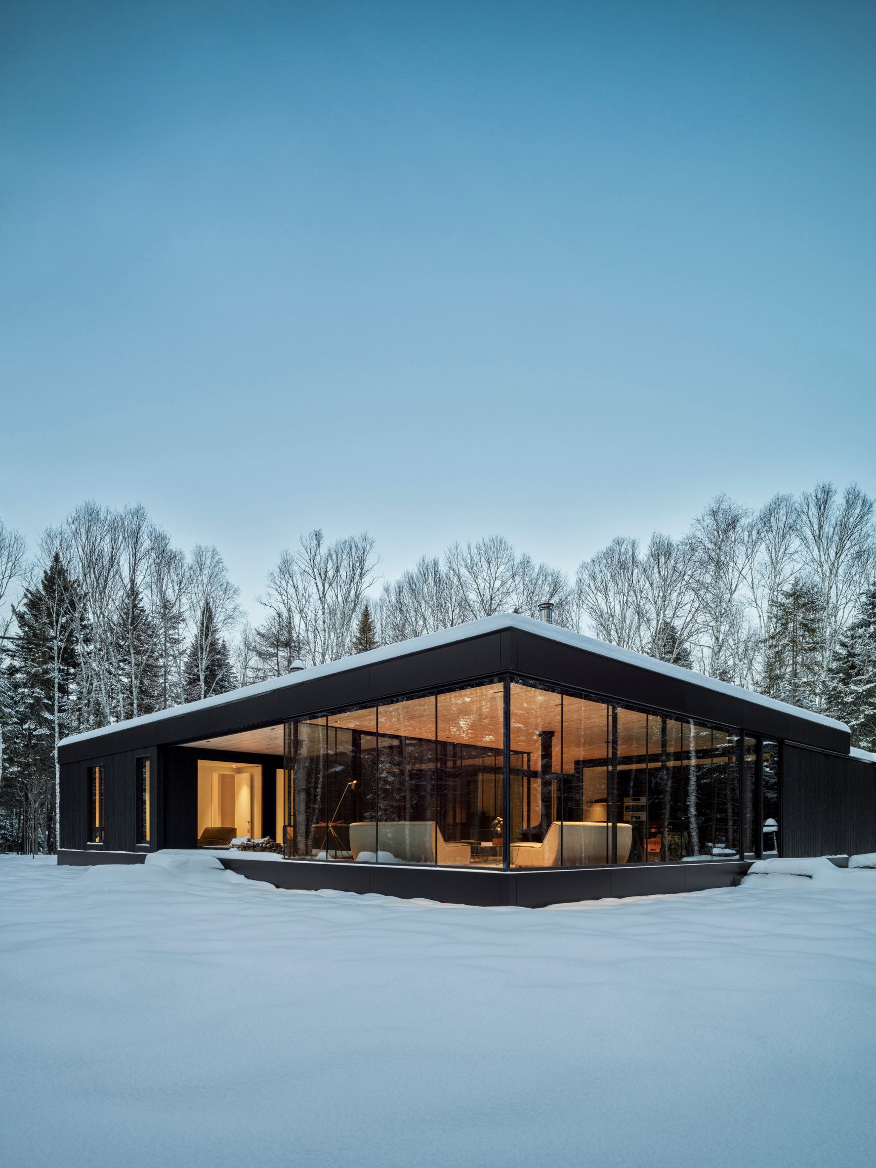 Black house with large glass windows by ACDF Architecture