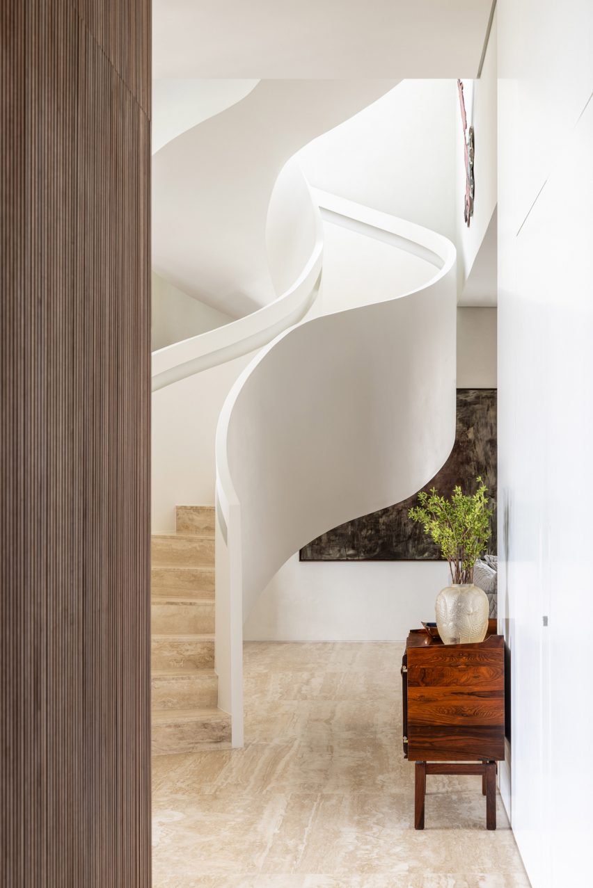 Staircase viewed beyond slatted timber wall