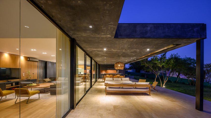 Salas de estar al aire libre en una casa de hormigón negro de AR Arquitectos