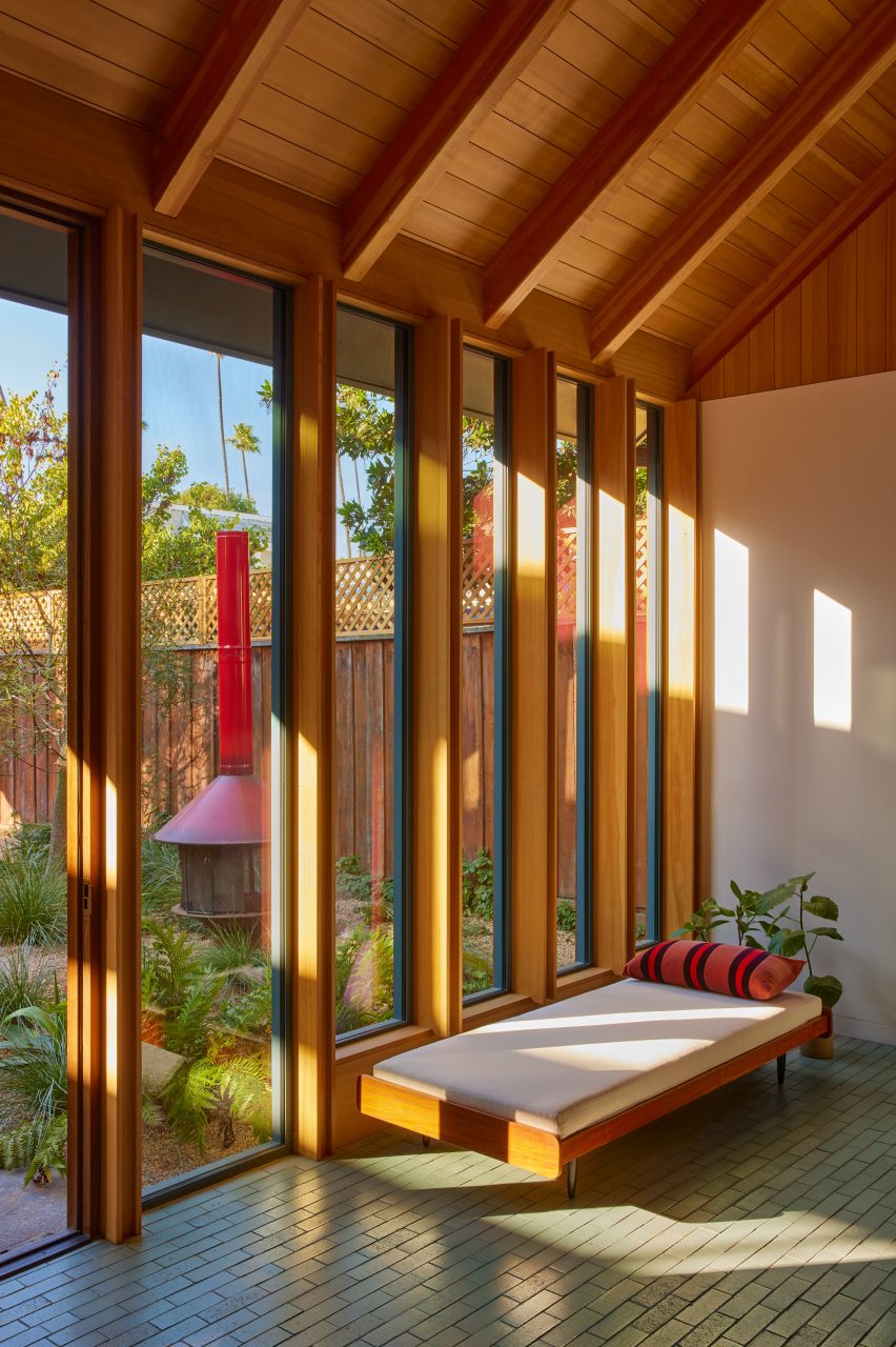 Chaise longue next to timber-clad window frames in Venice Beach cottage-style house