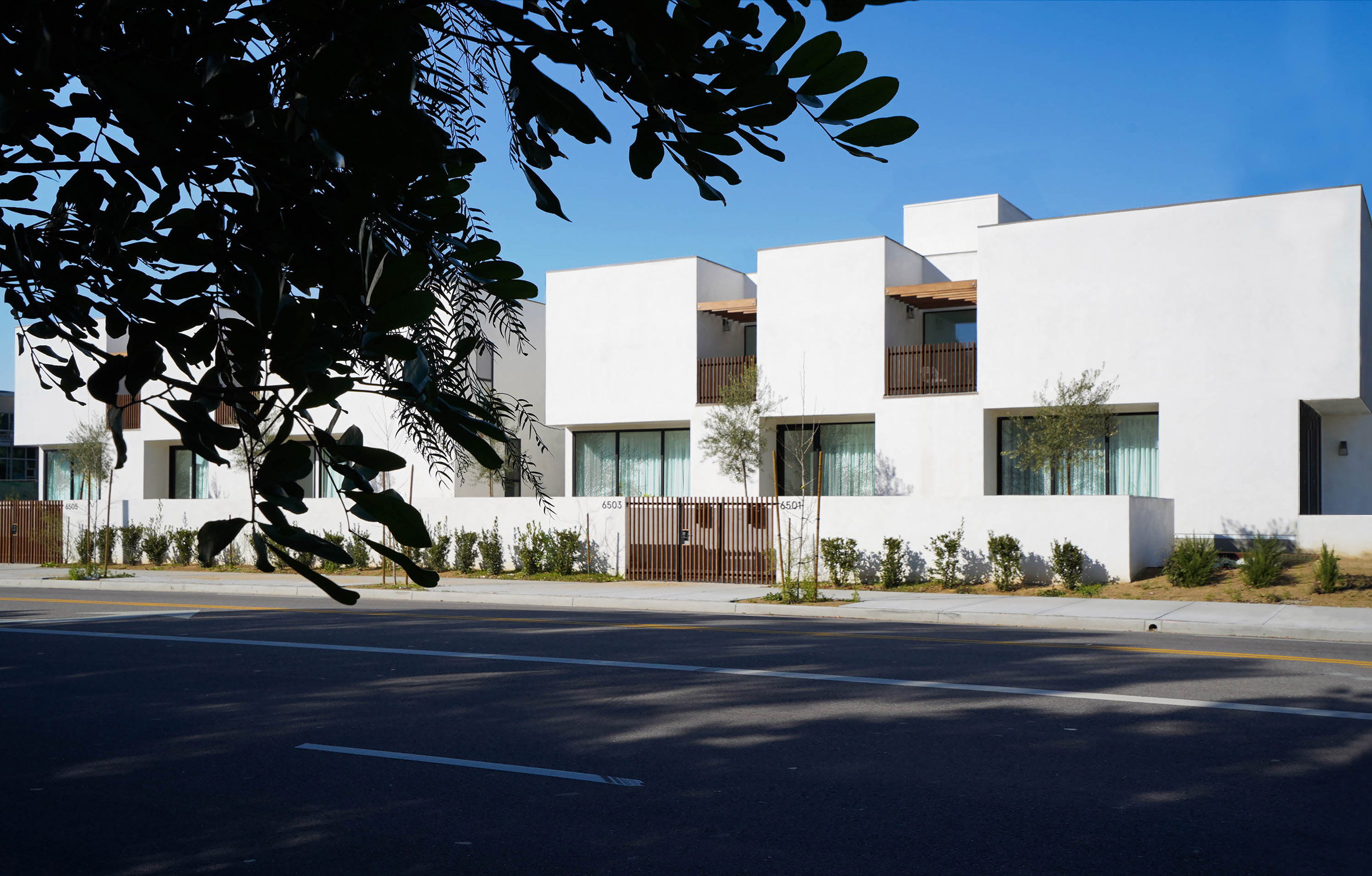 Low-slung rectilinear housing complex in LA clad in white stucco
