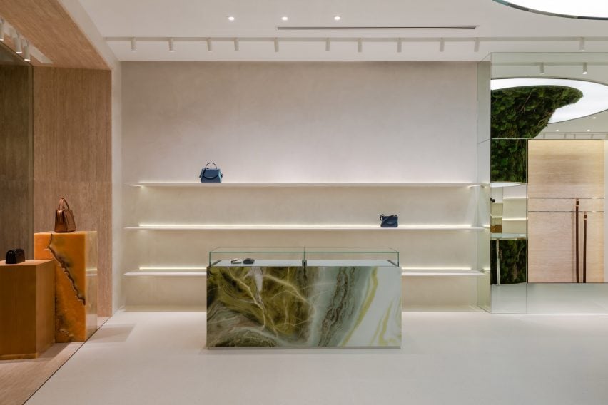 Green and orange marble and onyx cabinetry within store interior by Spacemen 