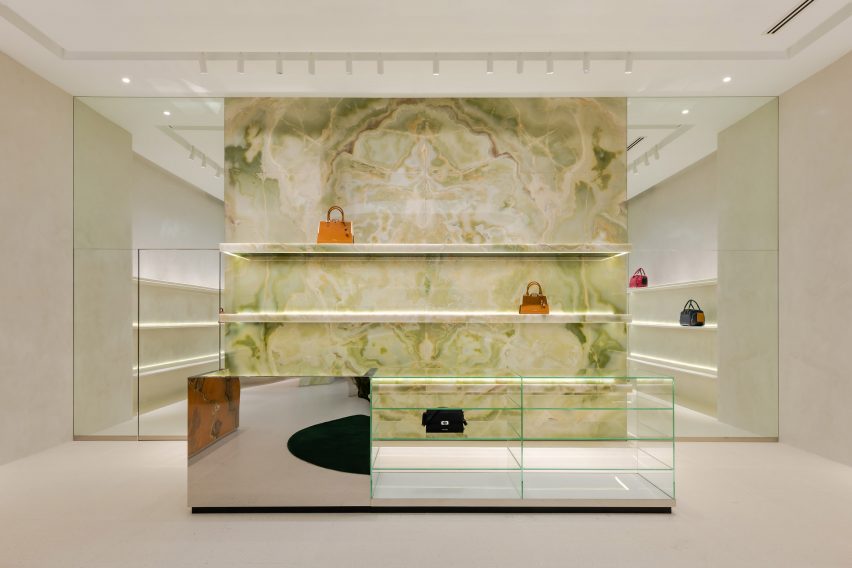 Green onyx feature wall with handbags displayed on its shelving