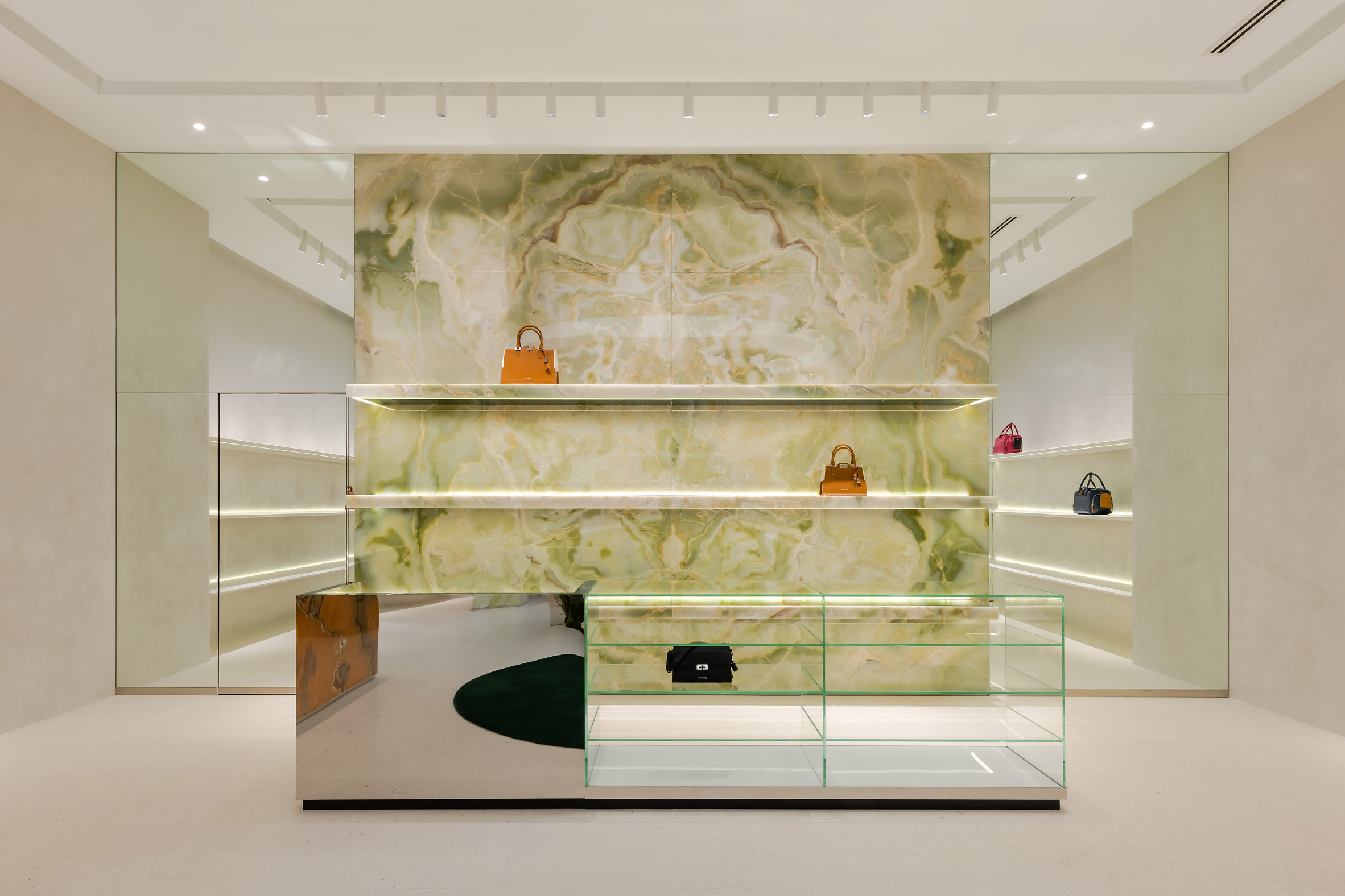 Green onyx feature wall with handbags displayed on its shelving