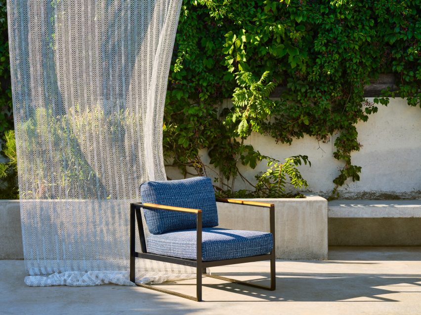 Photograph of chair in front of billowing drapery on outdoor terrace