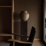 Chair and vase against a dark wall