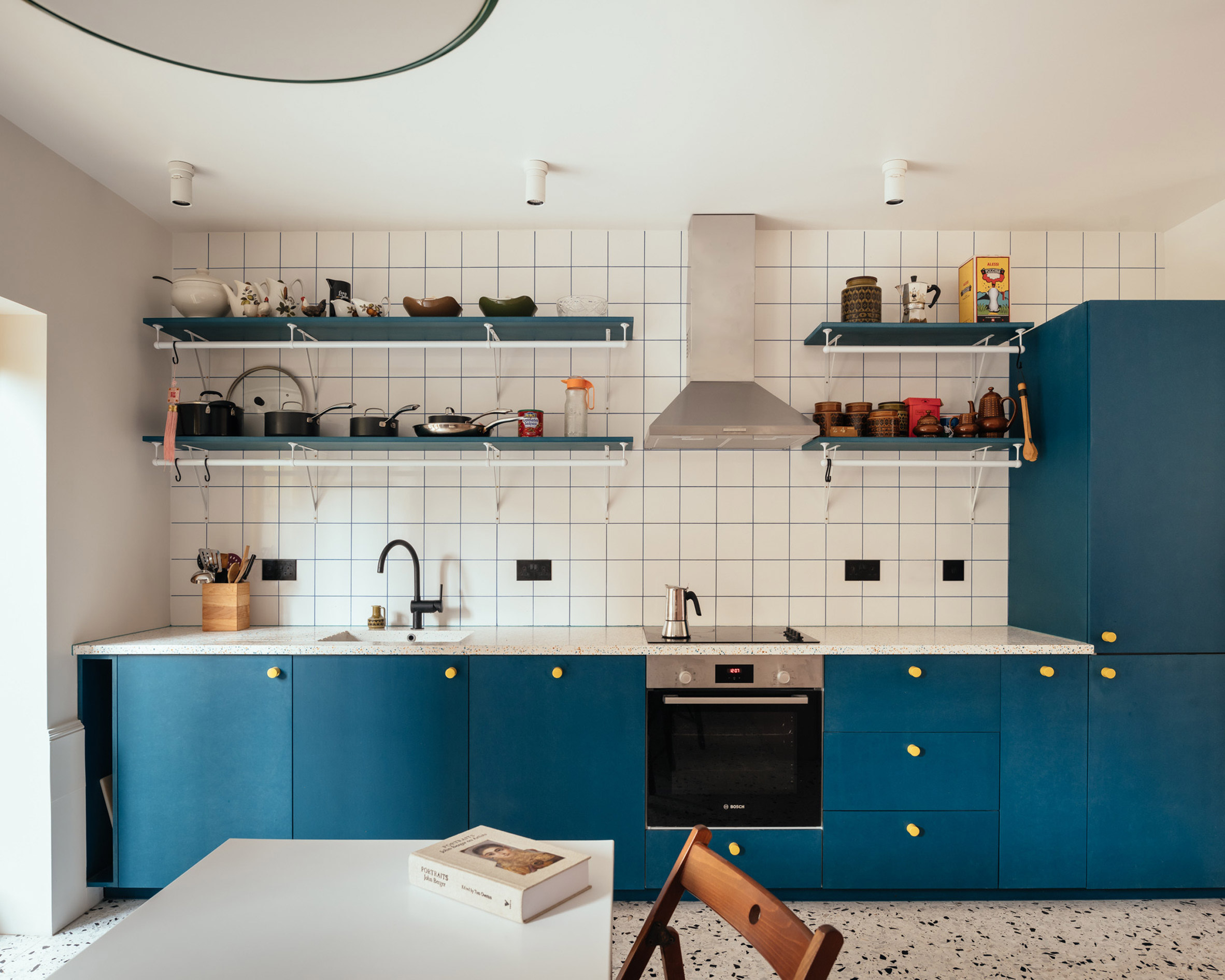 Kitchen with blue units and white tiles