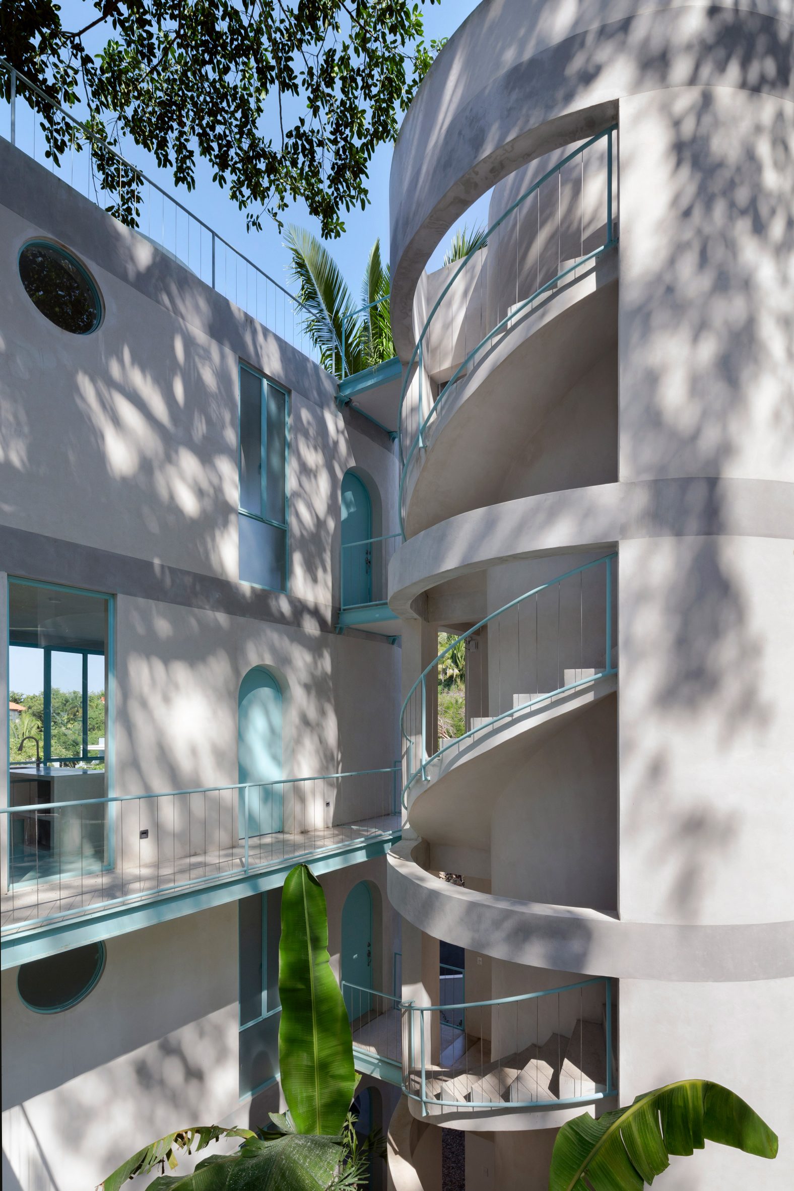 Rounded staircase on Mexican housing development with blue bannisters