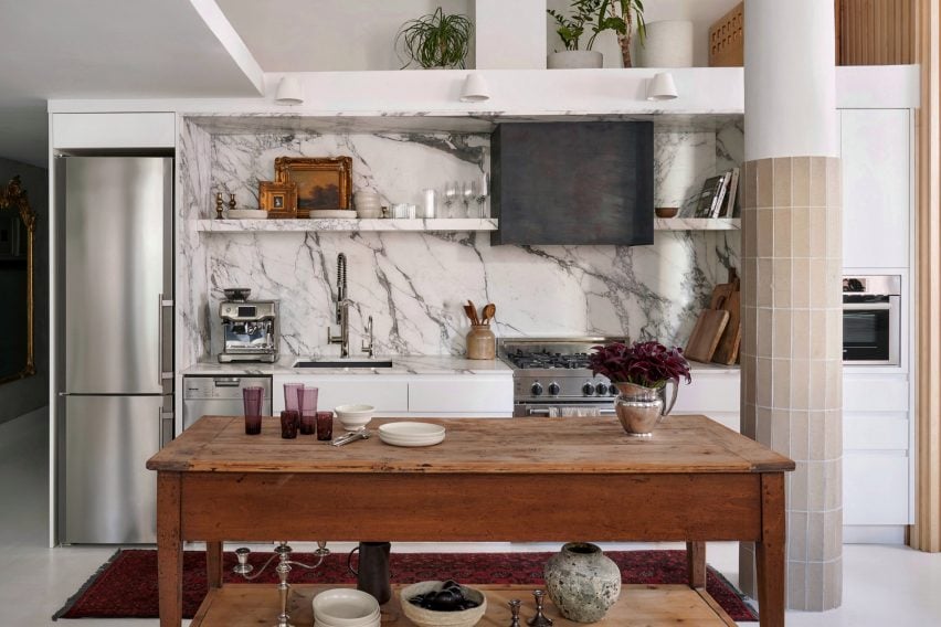 Kitchen with white and gray marble countertops and a farmhouse-style island