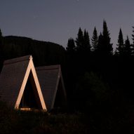 A-frame cabins at night with timber structure highlighted