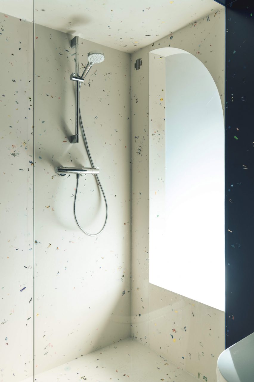Terrazzo cladding within compact shower room in micro apartment