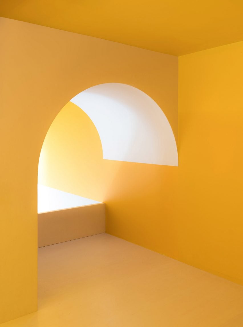 Arched yellow shape above the stairs in micro apartment