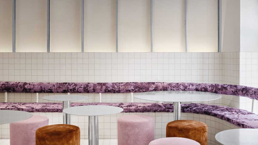 Purple banquette, pink and orange poufs, and metal tables