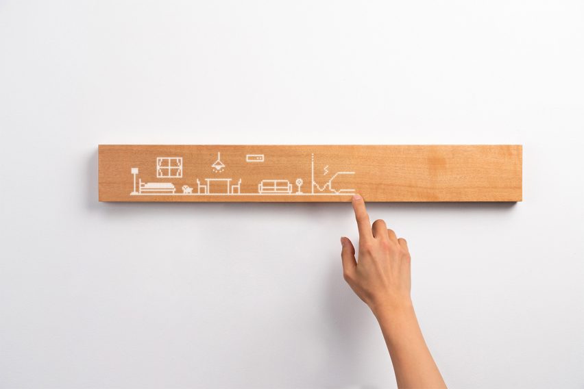 Photo of a hand finger-drawing domestic objects in a line on the wooden Mui Board