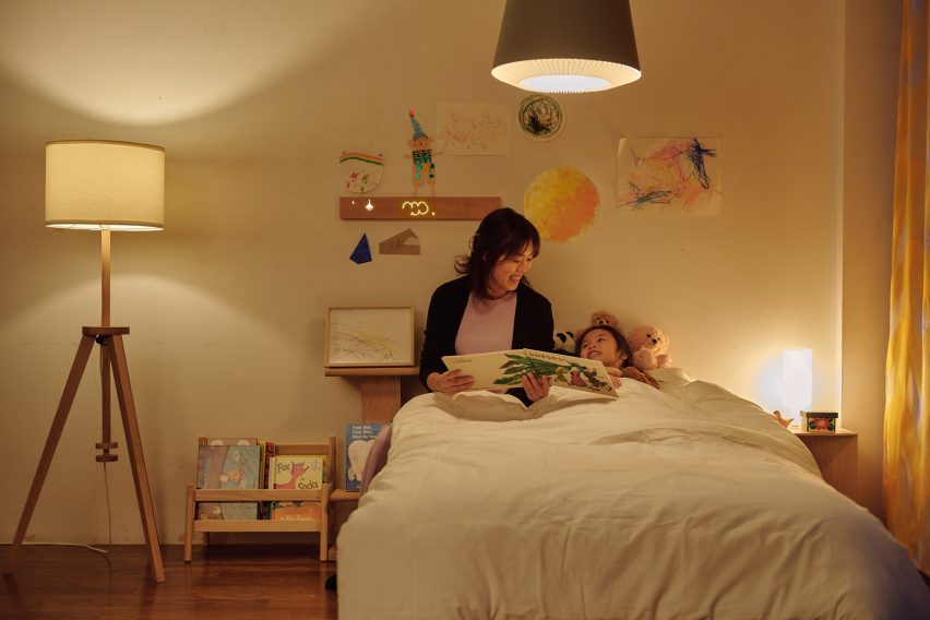 Photo of a mother reading to a child in the child's bedroom in dimmed warm light