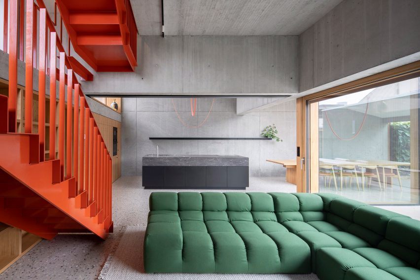 Living room with exposed concrete walls and metal staircase
