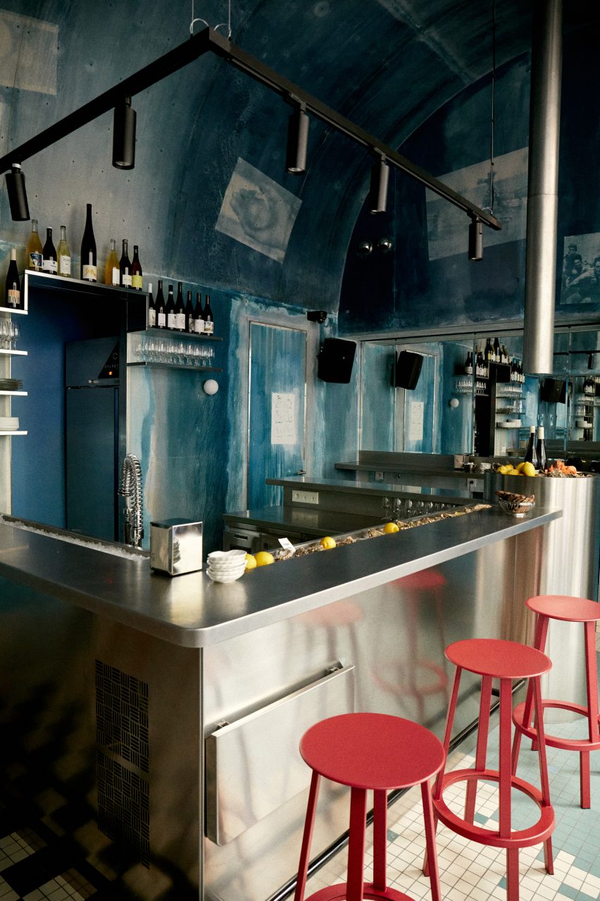 Citrons et Huîtres features a stainless steel centre with coral-coloured stools and blue walls