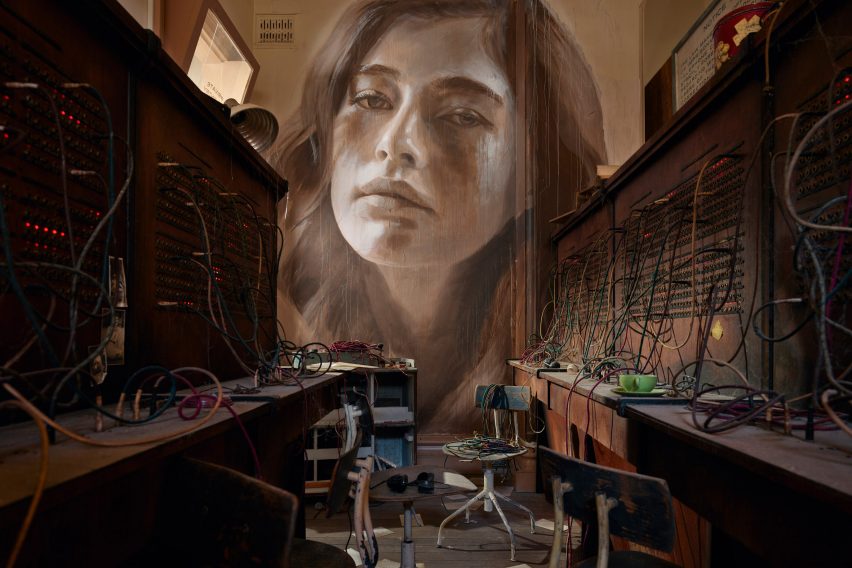 Wooden desks and large portrait at the Time exhibition by Rone