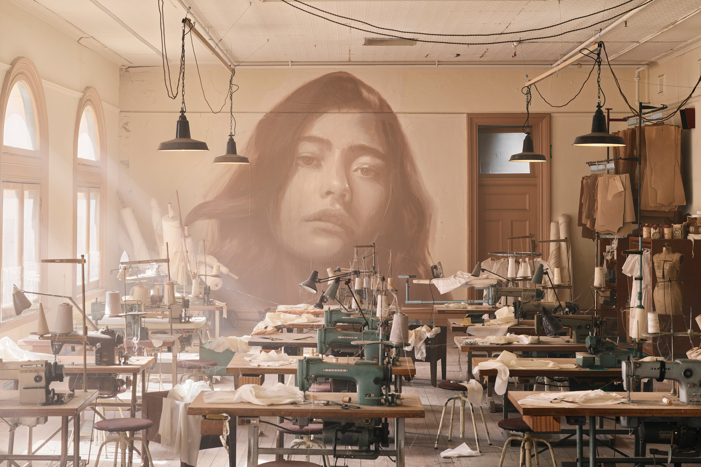 Industrial interior with rows of sewing machines at the Time exhibition by Rone