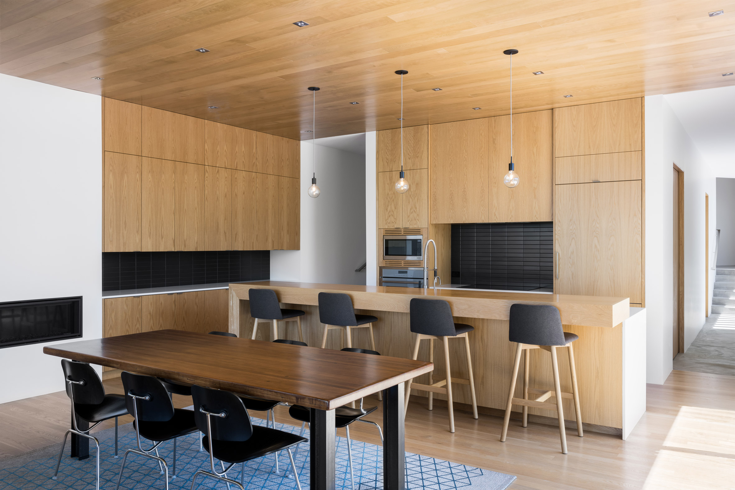 Light timber-clad kitchen interior with geometric cabinetry