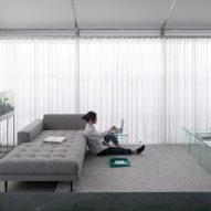 Sofa in a living room with white curtain walls
